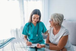 Medical Assistant Working With Older Woman