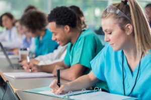 Nurses in training take notes during a lecture