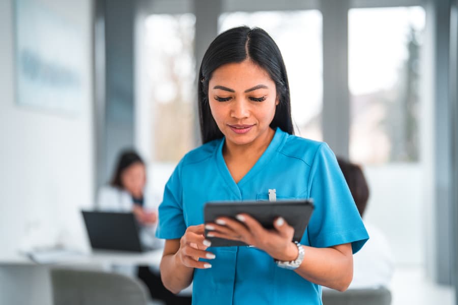 Neurology medical assistant reviews medical information on digital tablet 